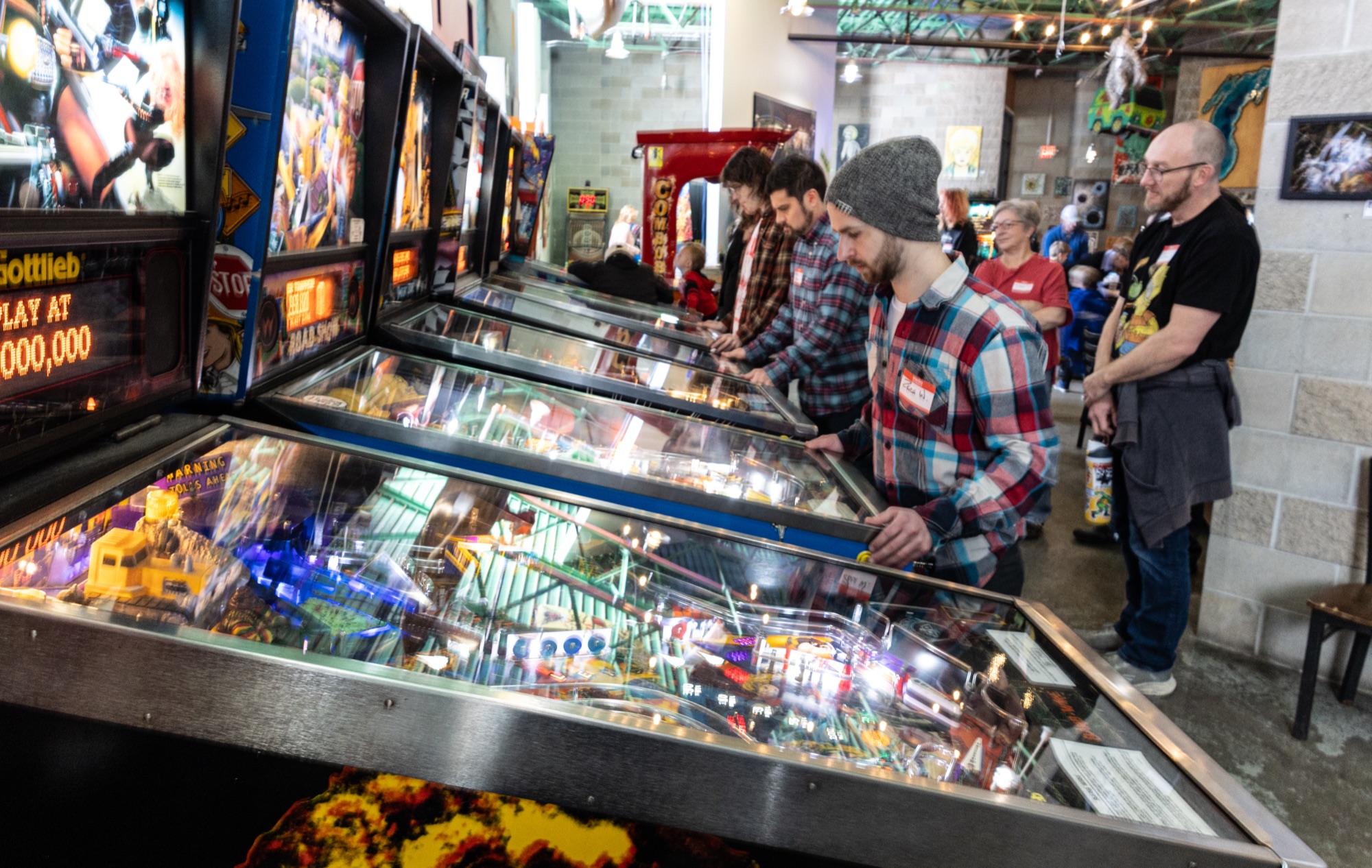 Players at the pinball machines at Right Brain Brewery